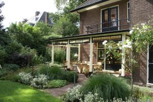 a garden with a patio and a house at Apartment in Romantic Villa in Bilthoven