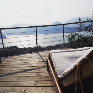 a mattress on a deck with a view of the ocean at Villa Romele in Pisogne