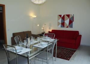 クアルトゥ・サンテーレナにあるcasa carlettaのダイニングルーム(テーブル、椅子、赤いソファ付)