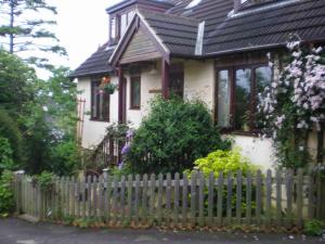 een wit huis met een hek ervoor bij Skerries B and B in Lyme Regis