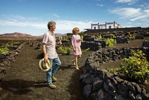 a man and a woman walking through a garden at Rooms & Suites Terrace 3A in Arrecife