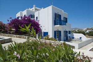 a large white house with a blue roof at Gryparis' Club Apartments in Mikonos