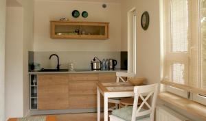 a kitchen with a wooden table and a kitchen counters at Apartamenty Turystyczne WillkasSen in Giżycko
