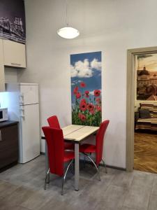 een keuken en eetkamer met een tafel en rode stoelen bij Apartment on Khorvatska Street in Lviv