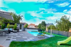 a backyard with a pool with chairs and a table at Gîtes Spa Strasbourg - La Villa 14 in Furdenheim