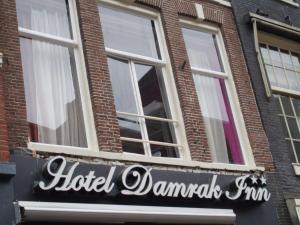 a sign for a hotel damascus firm in front of a building at Hotel Damrak Inn in Amsterdam +46 photos