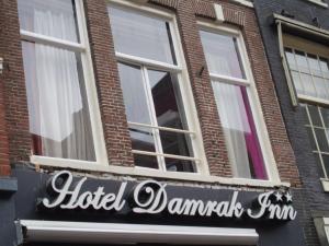 a sign for a hotel damascus firm in front of a building at Hotel Damrak Inn in Amsterdam