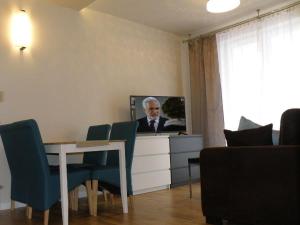 sala de estar con mesa con sillas y TV en Turkus, en Polanica-Zdrój