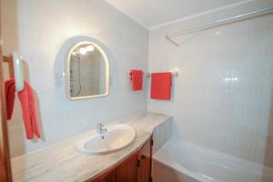 une salle de bains avec lavabo et baignoire dans l'établissement Luz Beach Ocean Front Apartment, à Luz 24 autres photos