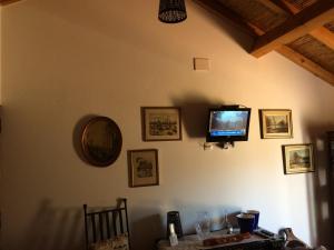 a living room with a television on the wall at Quarto Monte Ninho das Perdizes in Cercal