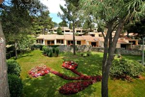 ein Haus mit einem Blumengarten im Hof in der Unterkunft Apartments Bellevue Plava Laguna in Poreč