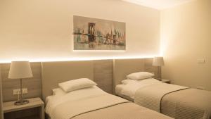 sypialnia z 2 łóżkami i obrazem na ścianie w obiekcie Hotel Magdalena w Zagrzebiu