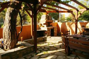 a wooden pergola with a tree and a bench at Inanthi in Potos