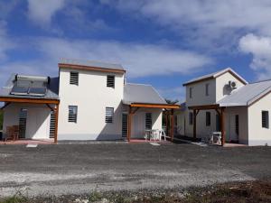 une rangée de maisons blanches avec toits dans l'établissement KAZ's à l'Anse Maurice, à Gros Cap