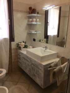 bagno con lavandino, specchio e servizi igienici di Casa Lella a Montecatini Terme