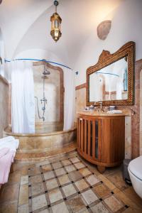 a bathroom with a tub and a sink and a mirror at Above The Spring in Jerusalem