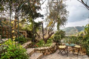 een patio met een tafel en stoelen in een tuin bij Above The Spring in Jeruzalem