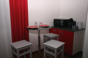 a small kitchen with two wine glasses and two stools at Studio Le Virgile - Annecy in Annecy