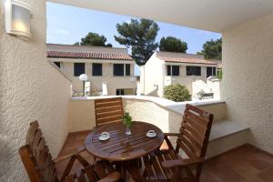 a wooden table and chairs on a balcony at Apartments Bellevue Plava Laguna in Poreč