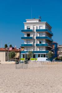 a building on the beach next to a sandy beach at Hotel Sayonara in Senigallia