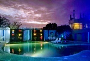 una piscina en un patio por la noche en Rio Suites, en Tonsupa