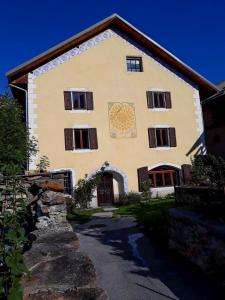 una grande casa con un muro di pietra di fronte di Bed and Breakfast Les Airelles a Val-des-Prés