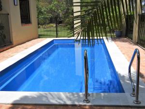 a swimming pool with a blue and white tub at Shady Grove B&B in Hervey Bay