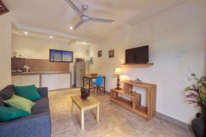 a living room with a blue couch and a kitchen at Tamarindo Garden Boutique Homes in Tamarindo