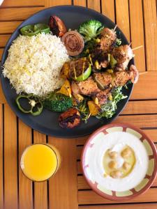um prato de alimentos com arroz e legumes sobre uma mesa em Triple Tree em Al-Hofuf