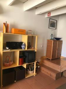 a room with a shelf with a tv on it at ADOBE TYPICAL COTTAGE in AlpalhÃ£o