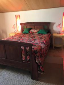 a bedroom with a large wooden bed with green pillows at ADOBE TYPICAL COTTAGE in AlpalhÃ£o