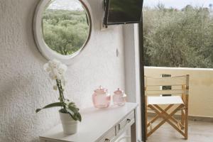 a vase of flowers on a table with a window at Elounda George Studios in Elounda