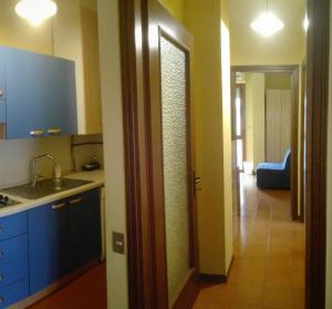 une cuisine avec un évier et une porte menant à un couloir dans l'établissement WelcHome - Cisanello, à Pise