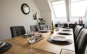 a dining room table with chairs and a clock on the wall at Villa&Loge in Lontzen