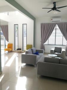 a living room with two couches and a ceiling fan at Desaru Arcadia Semi D Rooms Rental Available in Desaru