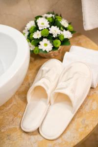 a pair of white shoes and a vase of flowers at Relais Maddalena in Rome