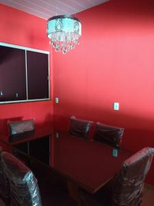 a red room with two chairs and a tv at Casa super confortável. in Anápolis