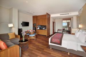 a hotel room with a bed and a living room at Swiss-Belhotel Airport Jakarta in Tangerang
