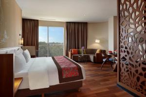 a hotel room with a bed and a living room at Swiss-Belhotel Airport Jakarta in Tangerang