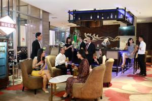a group of people sitting in chairs in a lobby at Swiss-Belhotel Airport Jakarta in Tangerang