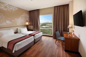 a hotel room with two beds and a window at Swiss-Belhotel Airport Jakarta in Tangerang