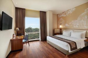 a hotel room with a bed and a large window at Swiss-Belhotel Airport Jakarta in Tangerang