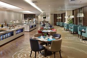 Swiss-Belhotel Airport Jakarta في تانغيرانغ: مطعم بطاولات وكراسي وكفتريا