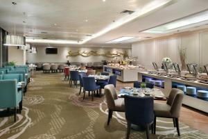 a restaurant with tables and chairs and a bar at Swiss-Belhotel Airport Jakarta in Tangerang
