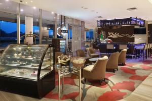 a restaurant with a display case and chairs and tables at Swiss-Belhotel Airport Jakarta in Tangerang