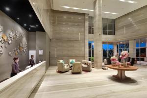 a lobby with couches and chairs and a table at Swiss-Belhotel Airport Jakarta in Tangerang