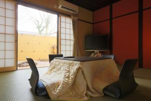 a room with a table with chairs and a window at Daisenji Lodge Ing 墨 地下鉄鞍馬口駅から徒歩1分 in Kyoto