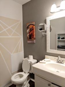 a bathroom with a toilet and a sink and a mirror at Exclusive Townhome - Central Raleigh Location in Raleigh