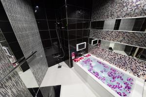 a bathroom with a tub filled with pink flowers at Restay Koakuma (Adult Only) in Utsunomiya