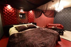 1 dormitorio con cama grande y pared roja en Restay Koakuma (Adult Only), en Utsunomiya